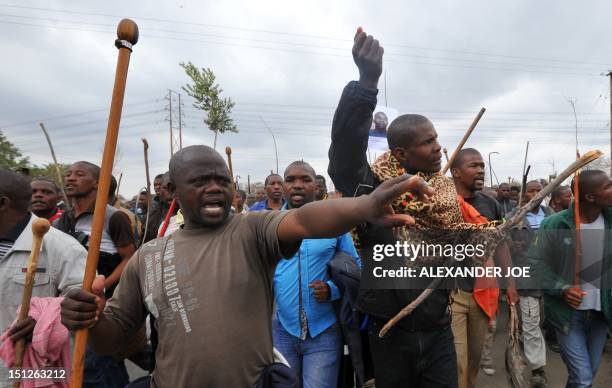 Thousands of striking miners singing and carrying sticks march on the Lonmin Marikana mine on Sepember 5 as workers accused police of shooting their...