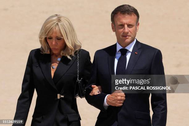 French President Emmanuel Macron and his wife Brigitte Macron leave following a national tribute to late Leon Gautier, French WWII veteran and the...