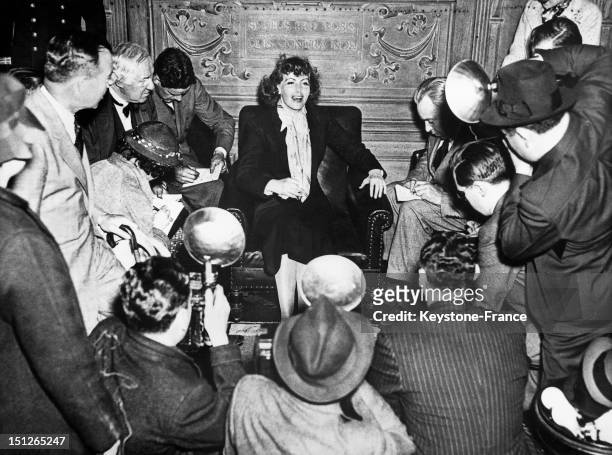 Greta Garbo with photographers swarming around her in a lounge on the "Gripsholm' ocean liner which was bringing her back to the United States after...