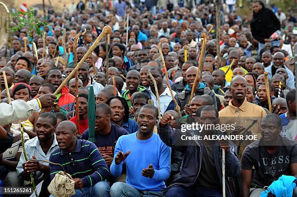 Thousands of striking workers singing and carrying sticks march on a South African mine in Marikana on Sepember 5 as police were accused of shooting...