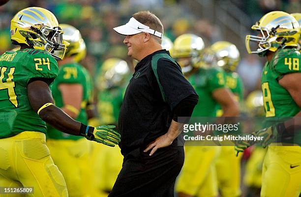 Head coach Chip Kelly of the Oregon Ducks talks to Kenjon Barner during warm ups against the Arkansas State Red Wolves on September 1, 2012 at Autzen...