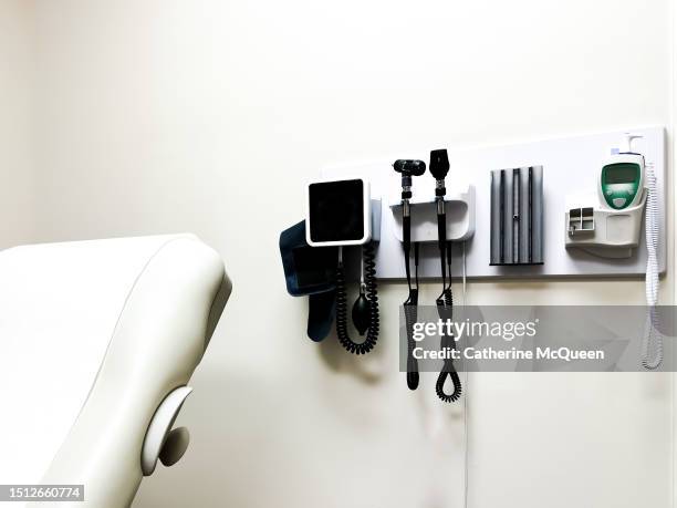 access to medical care: wall-mounted panel of medical diagnostic equipment beside standard patient examination chair - doctors office stock pictures, royalty-free photos & images