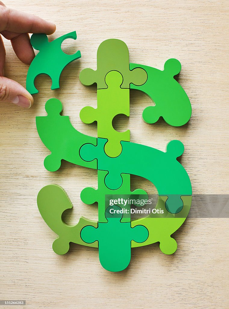 Dollar currency sign puzzle, last piece positioned