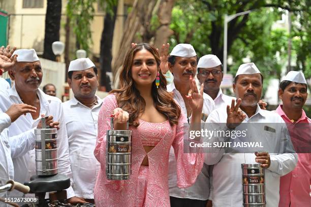 Bollywood actress Huma Qureshi poses for a picture with Mumbai 'Dabbawalas', lunchbox delivery men, during the promotion of the film 'Tarla' in...