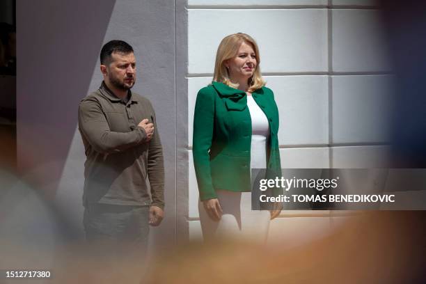 Slovak President Zuzana Caputova and Ukrainian President Volodymyr Zelensky review a military honor guard in front of the Presidential Palace in...