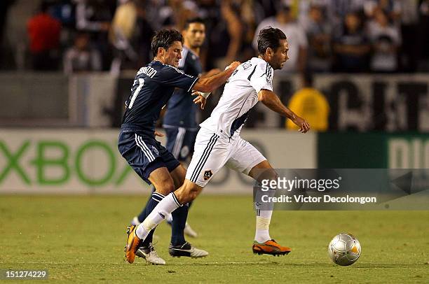 Marcelo Sarvas of the Los Angeles Galaxy plays the ball across the field under pressure from John Thorrington of the Vancouver Whitecaps during the...