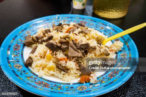 xinjiang lamb pilaf hand grasping rice - pilafrijst stockfoto's en -beelden