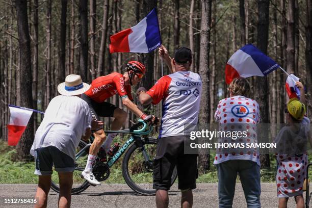 Team Arkea - Samsic's French rider Simon Guglielmi cycles in a breakaway past spectators waving French national flags during the 7th stage of the...