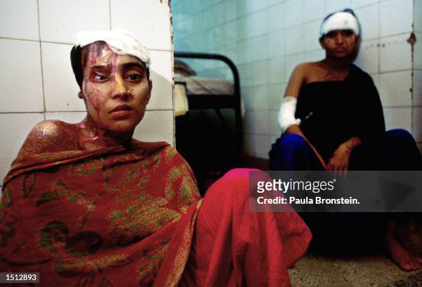 Jerina, left, age 23, sits in a hospital in Dhaka, Bangladesh July 2000 four months after a jilted boyfriend attacked her with battery acid. Another...