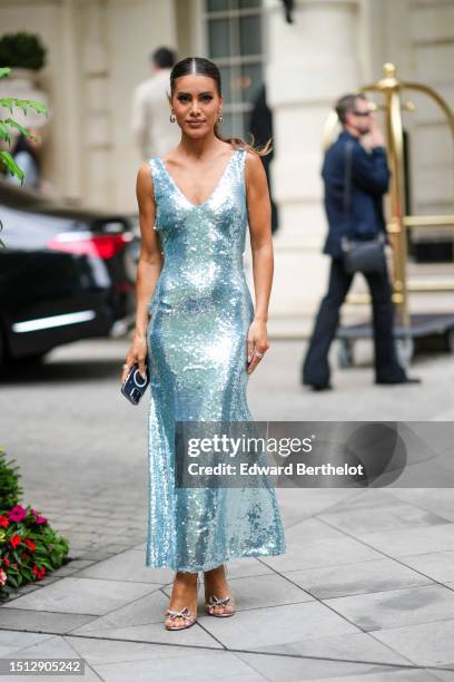 Camila Coelho wears gold with large silver pearls earrings, a pale blue embroidered sequined V-neck / tank-top long dress, silver rings, transparent...