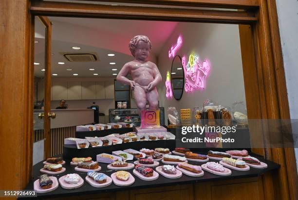 View of a chocolat shop window with a figurine of the famous Manneken Pis, a copie of the emblematic bronze sculpture of the fountain in the center...