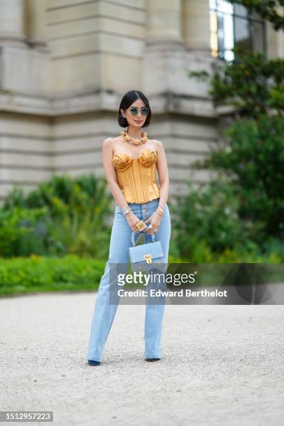Heart Evangelista wears navy blue circle sunglasses, diamond large earrings, a large gold and diamonds oversized necklace from Schiaparelli, a gold...