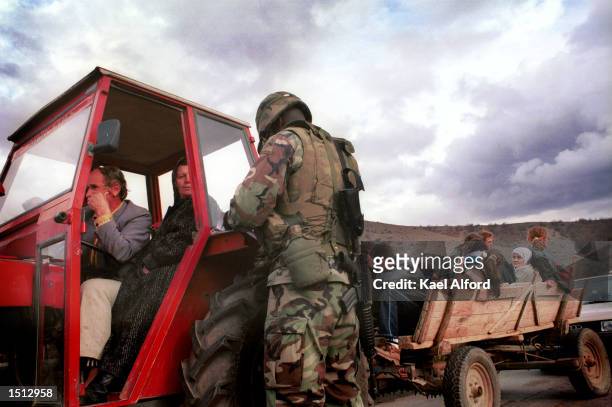 Albanian refugees from the Presevo valley pass through an American checkpoint November 26, 2000 on the boundary of Kosovo. Approximately 1200...