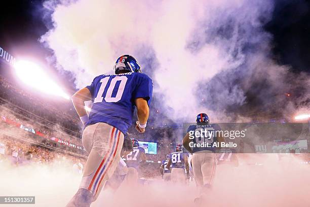 Quarterback Eli Manning, tackle Will Beatty and the rest of the New York Giants take the fileld prior to playing against the Dallas Cowboys during...