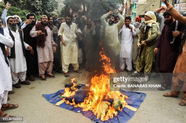 People shout slogans as they burn a flag of Sweden during a demonstration in Quetta on July 7 as they protest against the burning of the Koran...