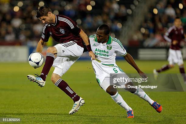 Drew Moor of the Colorado Rapids tries to control the ball as he is fouled by Darlington Nagbe of the Portland Timbers at Dick's Sporting Goods Park...