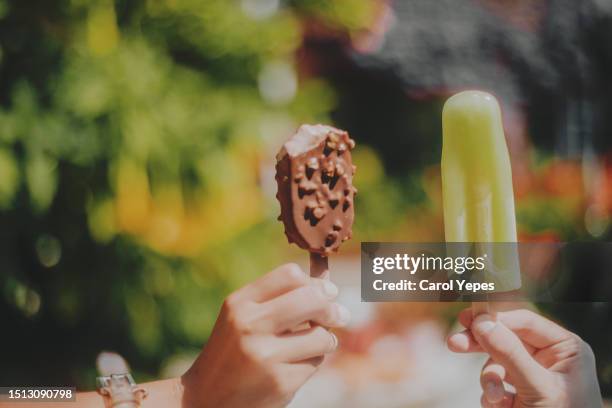 closeup  hands  holding chocolate popsicles - frost bite stock-fotos und bilder
