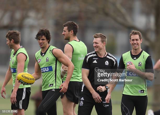 Scott Pendlebury and Nick Maxwell of the Magpies laugh with Nathan Buckley, coach of the Magpies during a Collingwood Magpies AFL training session at...