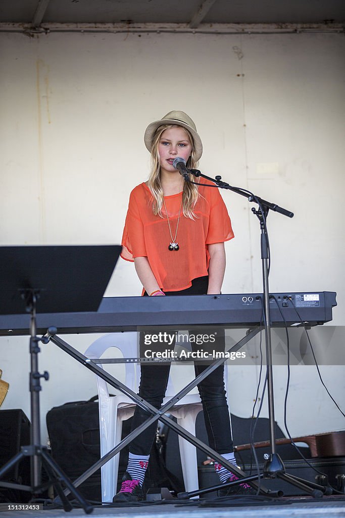 Teenage girl singing and playing keyboards