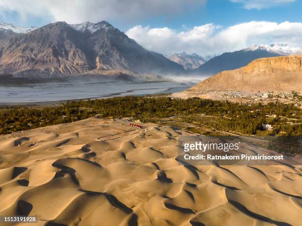 aerial drone view sunset landscape scene of katpana cold desert sand dune surrounded by snowcapped mountain from karakoram range, skardu, northern of pakistan - skardu stock pictures, royalty-free photos & images