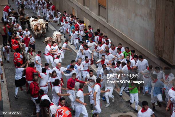 Group of men run away from 11 bulls in the vicinity of Casa Seminario. People ran in front of the bulls in the first running of the bulls of the San...