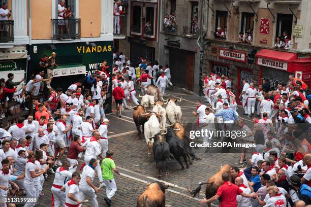 Bulls chase people during the traditional San Fermin festival. People ran in front of the bulls in the first running of the bulls of the San Fermin...