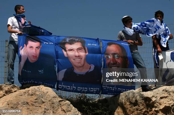 Israelis hold posters of the two Israeli soldiers, Eldad Regev and Ehud Goldwasser , held by Hezbollah in Lebanon and Gilad Schalit held by Hamas in...