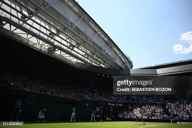 Spain's Carlos Alcaraz returns the ball to France's Alexandre Muller during their men's singles tennis match on Centre Court on the fifth day of the...