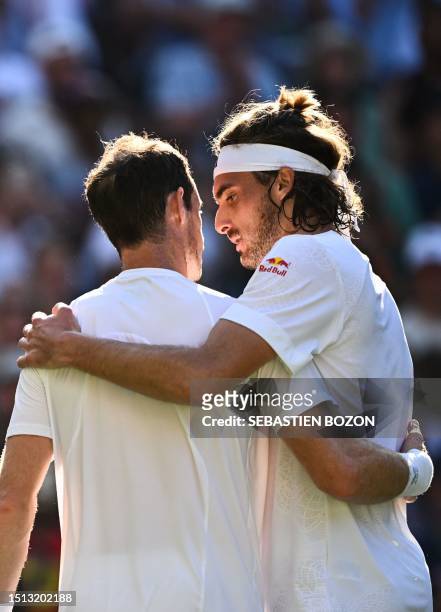 Greece's Stefanos Tsitsipas hugs Britain's Andy Murray after winning their men's singles tennis match on the fifth day of the 2023 Wimbledon...