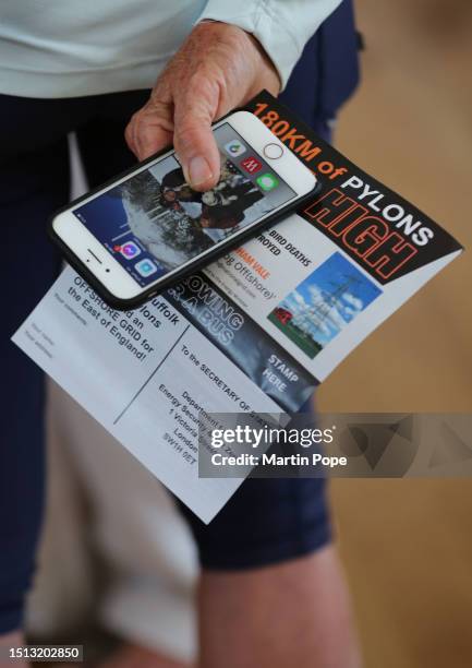 Protester holds a leaflet criticising the 50km high pylons at the drop in consultation at the community centre on July 7, 2023 in Diss, United...
