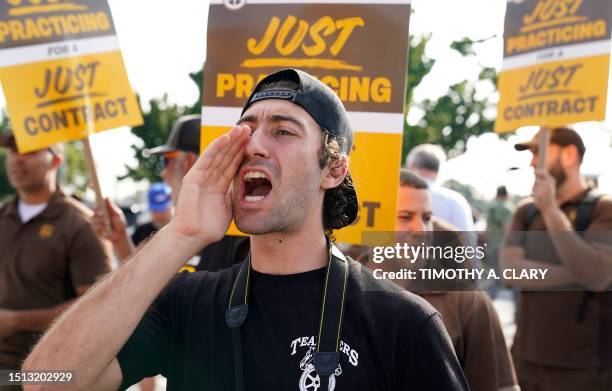 United Parcel Services workers walk a 'practice picket line' on July 7 in the Queens borough of New York City, ahead of a possible UPS strike. UPS...