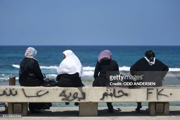 Family and women sit along the Mediterranean waterfront in Benghazi on April 12 as Libyan rebels rejected on the eve an African Union initiative for...