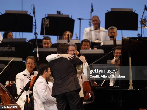 Hollywood, CA Javier Perianes, left, who soloed on piano, hugs Gustavo Dudamel after conducting the Los Angeles Philharmonic, performing Mussorgsky,...