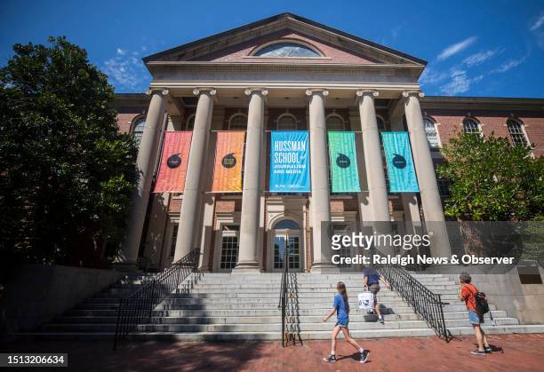 Visitors of UNC-Chapel Hill walk up the steps of Carroll Hall, the building housing the Hussman School of Journalism and Media, in Chapel Hill, North...