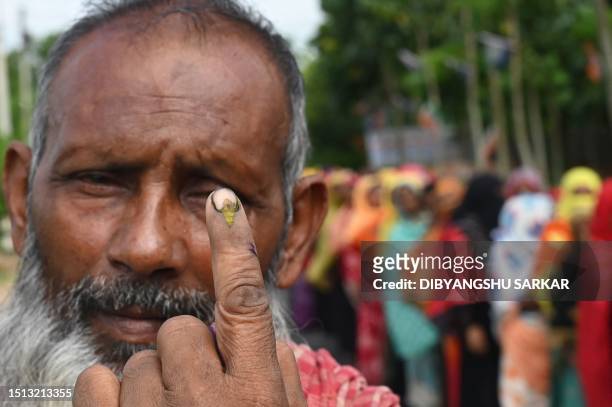 Man shows his ink marked finger after casting his vote in West Bengal's 'Panchayat' or local elections, outside a polling station on the outskirts of...