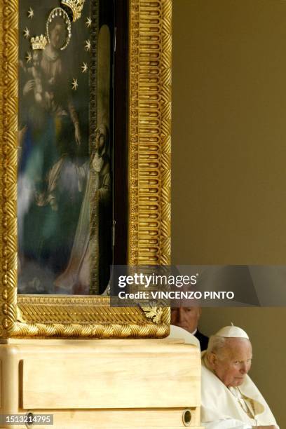 Pope John Paul II is taken past a painting of "Madonna del Rosario" as he makes his way to pray for world peace at the shrine of Virgin Mary in...