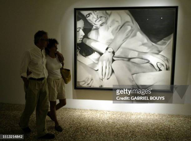 Couple look at "Lieber Maler, Male mir" an oil on canvas by German painter Martin Kippenberger at the Correr Museum during the 5Oth Biennale of Art...