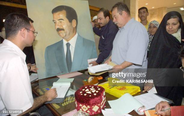 Iraqis present gifts to President Saddam Hussein at an art exhibition held on the occasion of Saddam's upcoming 65th birthday in Baghdad 25 April...