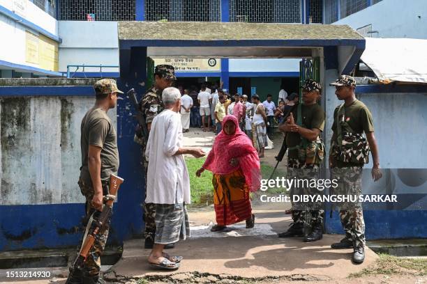 Paramilitary personnel stand guard at the entrance of a polling station during West Bengal's 'Panchayat' or local elections, on the outskirts of...