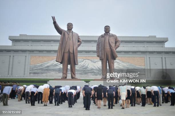 People pay tribute as they visit the statues of the late North Korean leaders Kim Il Sung and Kim Jong Il on the 29th anniversary of Kim Il Sung's...