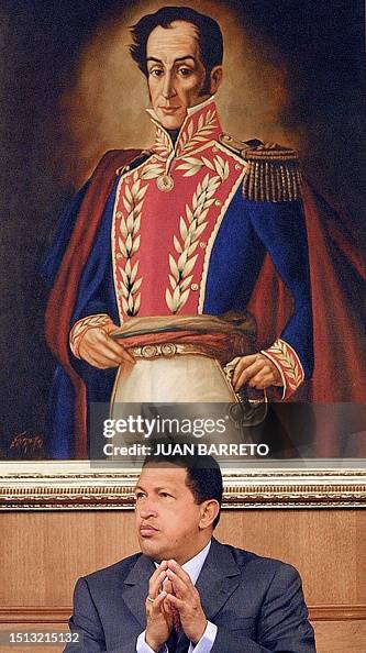 Hugo Ch A photo taken of venezuelan Hugo Chavez, sitting under a painting of ...