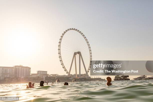 People swim in the warm Arabian Gulf at JBR Beach in the Dubai Marina on July 01, 2023 in Dubai United Arab Emirates.