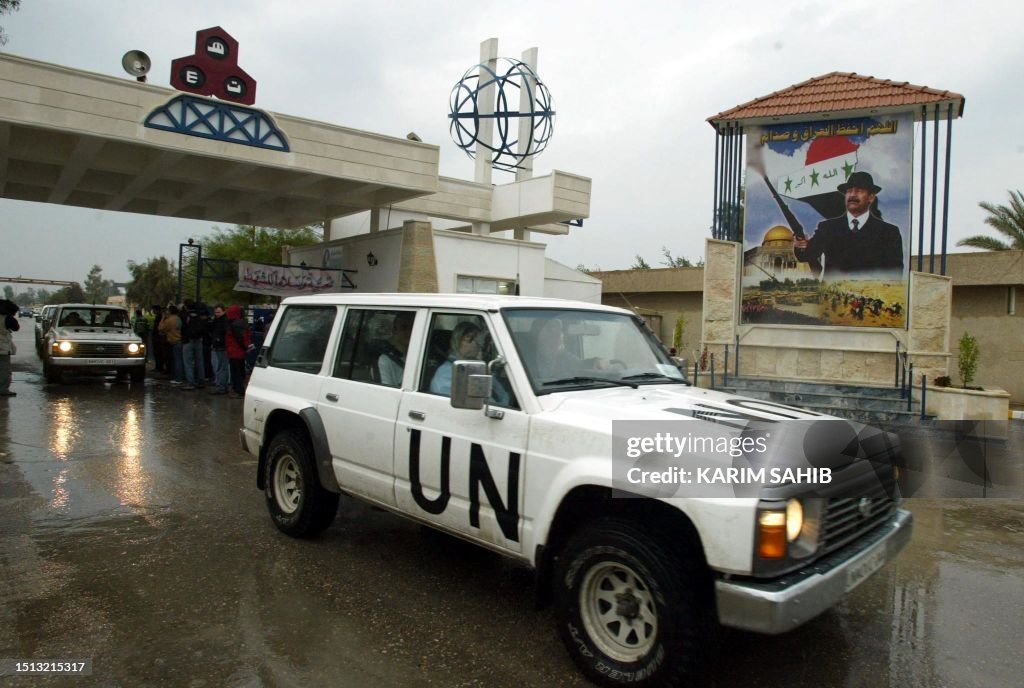 Iraq Un A United Nations vehicle carrying a team of inspectors drives past a ...