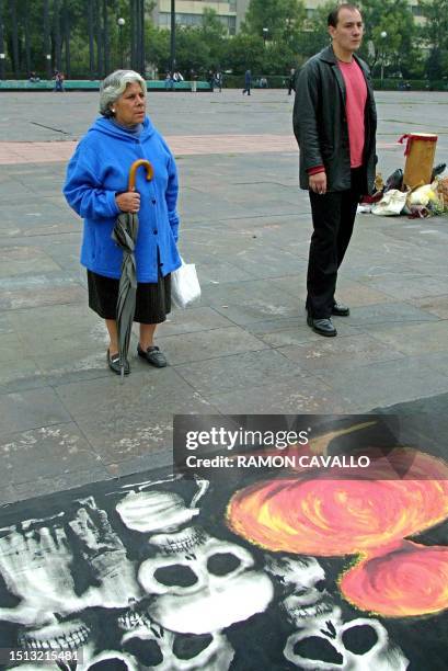 Man and woman in Mexico City observe the artwork on display to pay homage to the students that were killed in 1968, 02 October 2001. Una mujer y un...