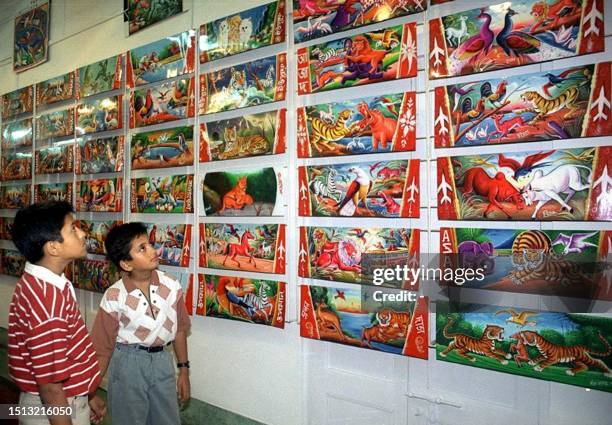 Two boys look at paintings rom rickshaws at an exhibition in Dhaka 02 October 1999. The exhibition is hoped to bring a wider artisitic acceptance of...