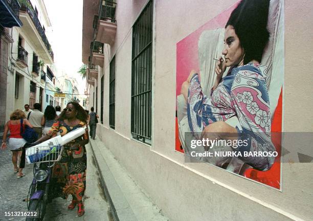 Woman passes by a painting by Venezuelan Ricardo Benain 17 November 2000 exhibited during the arts biennial. Una mujer pasa junto a una obra del...