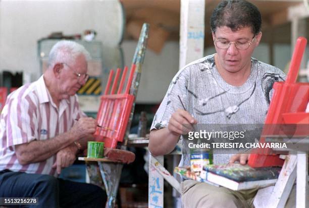Ricardo Burgos and Carlos Chaverri paint carts for souvenirs at the Joaquin Chaverri Cart Factory in Alajuela, Costa Rica, 11 January, 2000. Ricardo...