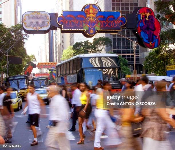 Residents of Rio de Janeiro crossed the Avenue Rio Branco, the principal street in the city, adorned for the Carnival festival, 28 February, 2000 in...