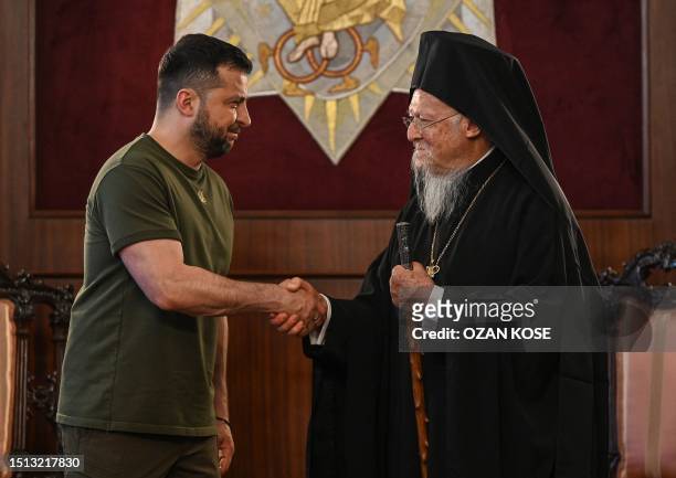 Ecumenical Patriarch Bartholomew I shakes hands with Ukraine's President Volodymyr Zelensky as they attend a joint press conference at the...