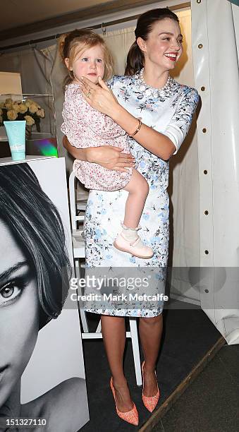 Miranda Kerr poses with a young child at a Kora Organics pop up store in Martin Place as part of Fashion's Night Out on September 6, 2012 in Sydney,...